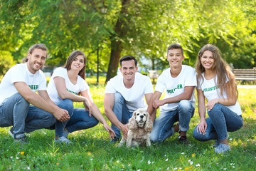 Volunteers with cute dog outdoors