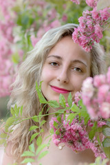 Fototapeta premium Portrait of a young woman in a park of roses