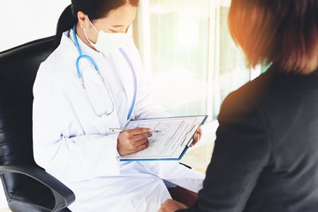 doctor woman asian note on medical record - medical examination report for diagnosis in the hospital - healthcare checks physician at work or nurse and patient are discussing about diagnosis