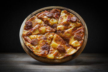 pizza on wooden plate delicious tasty fast food italian traditional pizza cheese with Mozzarella , Smoked pork sausage , Pineapple ham on topping sauce Restaurants or pizzerias on the dark