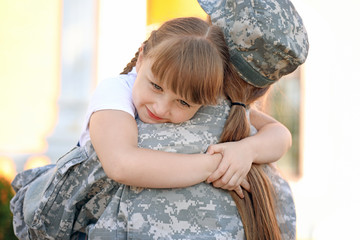 Happy little girl meeting her military mother outdoors