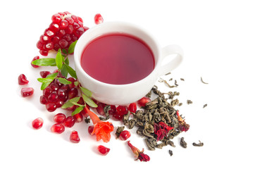 Parts of a pomegranate with pomegranate seeds and leaves, flowers, dry tea of carcade and full cup of tea isolated on white background
