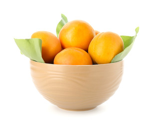 Bowl with tasty ripe apricots on white background