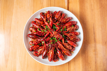 A large bowl of delicious braised crayfish on a wooden table