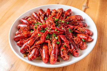 A large bowl of delicious braised crayfish on a wooden table