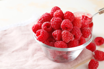 Bowl with ripe raspberry on table
