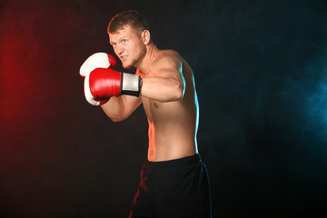 Strong male boxer on dark background