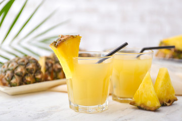 Glasses of fresh pineapple juice on table