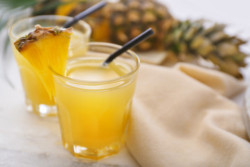 Glasses of fresh pineapple juice on table