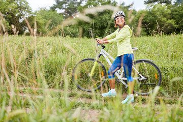 Obraz premium Sporty senior woman by mountain bike