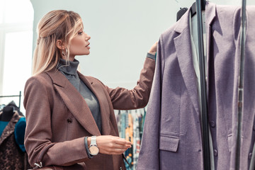 Businesswoman wearing hand watch choosing new jacket