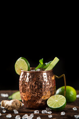 Famous splashing Moscow mule alcoholic cocktail in copper mugs, freeze motion effect.
