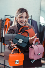 Businesswoman owning fashion boutique holding little hand bags