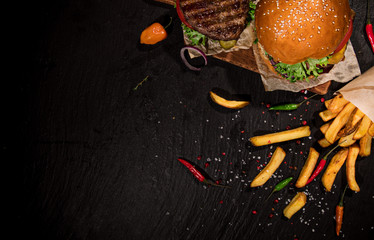 Top view of home made tasty burgers on black stone table. - obrazy, fototapety, plakaty
