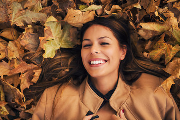 Smiling girl on autumn leaves