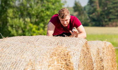 Naklejka na ściany i meble Haystack obstacles at the extreme race overcome by runner