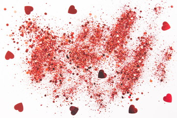 Red glitter with hearts on a white background. Background for your design.