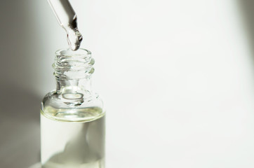 Cosmetic or medical glass bottle with pipette on white background. Skin care concept. Natural hard light, deep shadows. - Image