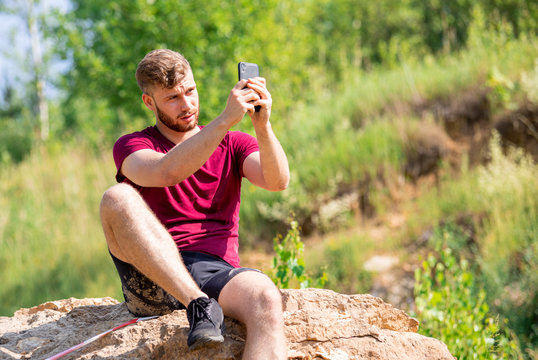 Fit man using smartphone to take a photo during training outdoor