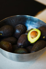 Ingredients for making avocado salad in a deep bowl on the table. 