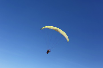 Man fly over blue sky as paragliding extreme sport 