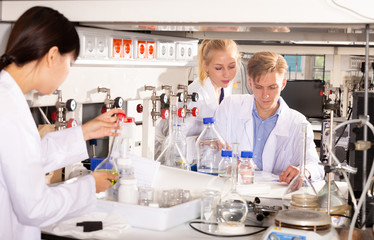 Student with female coursemates recording results of experiments