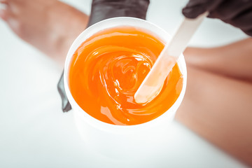 Concentrated beauty salon worker choosing sugar mixture