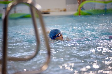 Children swimming competition in pool, relay race