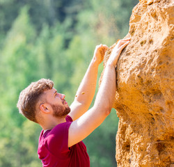 Fit man climbing on rocks obstacles in the boot camp