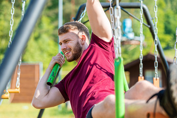 Fit man climbing monkey bars during obstacle course in boot camp