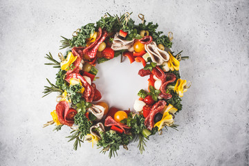 Christmas food background. Christmas wreath of holiday snacks, white background. © vaaseenaa