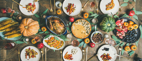 Thanksgiving, Friendsgiving holiday celebration. Flat-lay different meals at Thanksgiving Day table...