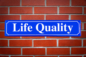 Life Quality street sign on brick wall