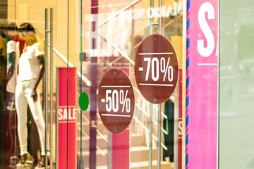 Sale sign 50 and 70 percent in a fashion clothes shop display window
