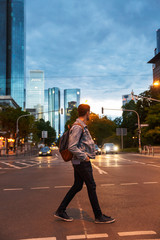 Attractive young man walking at the city streets in the evening