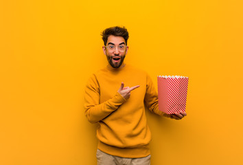 Young man holding popcorns holding something with hand