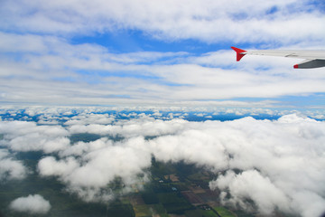 Wing of an airplane flying above the clouds