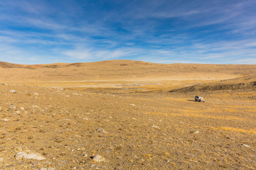 Fototapeta na wymiar Cold Desert of Gurudongmar lake in North Sikkim, India. Vast barrenness of a brutal terrain. Rugged landscape with blue skies. Eastern Himalayas. Minimalistic image at high altitude. Extreme adventure