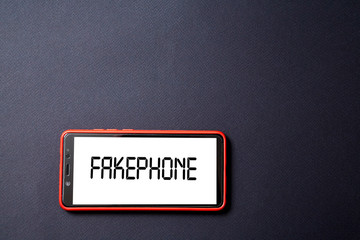 Fake news, disinformation or false information and propaganda concept. Smartphone and inscription on a black background.