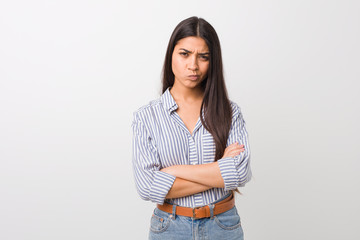 Young pretty arab woman frowning face in displeasure, keeps arms folded.