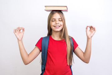 Fototapeta Diligent schoolgirl carrying book on head obraz