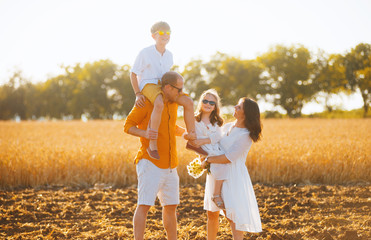 Photo of a family having fun in a field of wheat