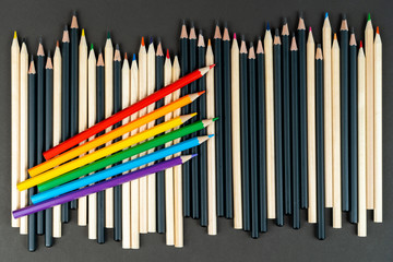 black, white and lgbt color pencils on black paper background. Mock up, copy space. concept of integration lgbt community in world. tolerance and interaction with homosexual people.