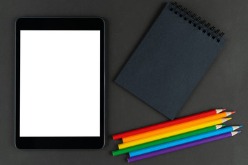 black notebook, lgbt colored pencils and tablet on black paper background. Mock up, Copy space. concept of different views on tolerance, outdated and modern ideas.