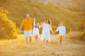 Fototapeta premium Photo of happy family walking and having fun in a field