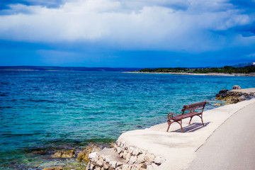 Fototapeta na wymiar Coastal panorama with bench seen from Lun, Croatia