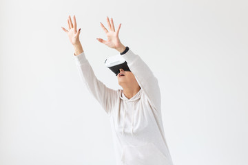 Positive pretty middle-aged woman in a white sweater watching a movie with glasses of virtual reality. The concept of futurism and new technologies.