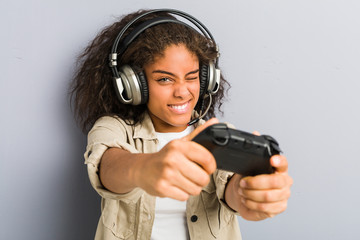 Young african american woman using headphones and game controller