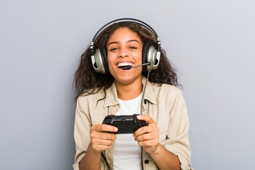 Young african american woman using headphones and game controller