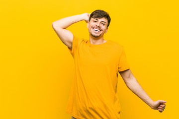 Young hispanic casual man stretching arms, relaxed position.